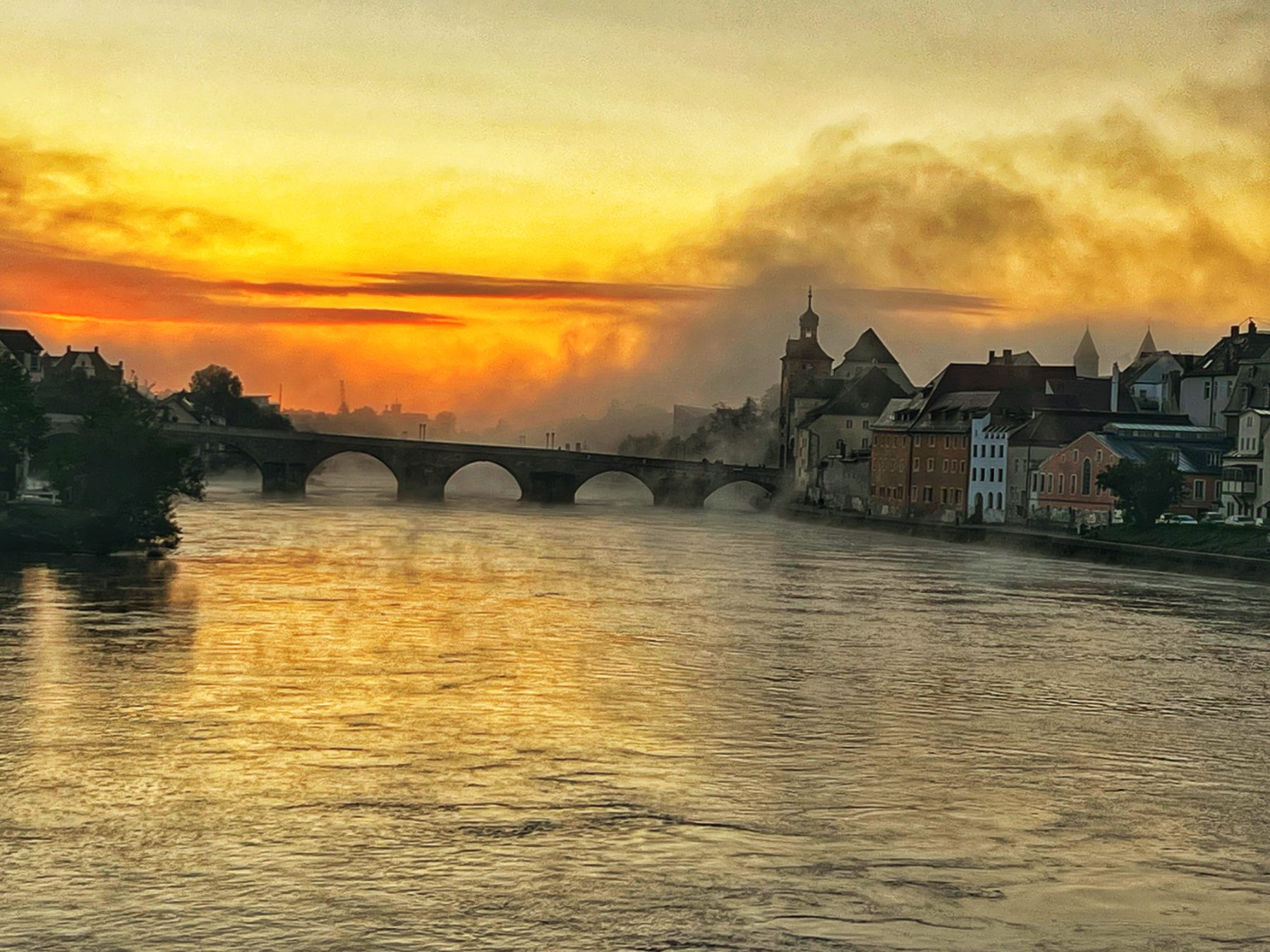 Sonnenaufgang über der Donau: Steinerne Brücke und der Regensburger Dom im Morgenlicht